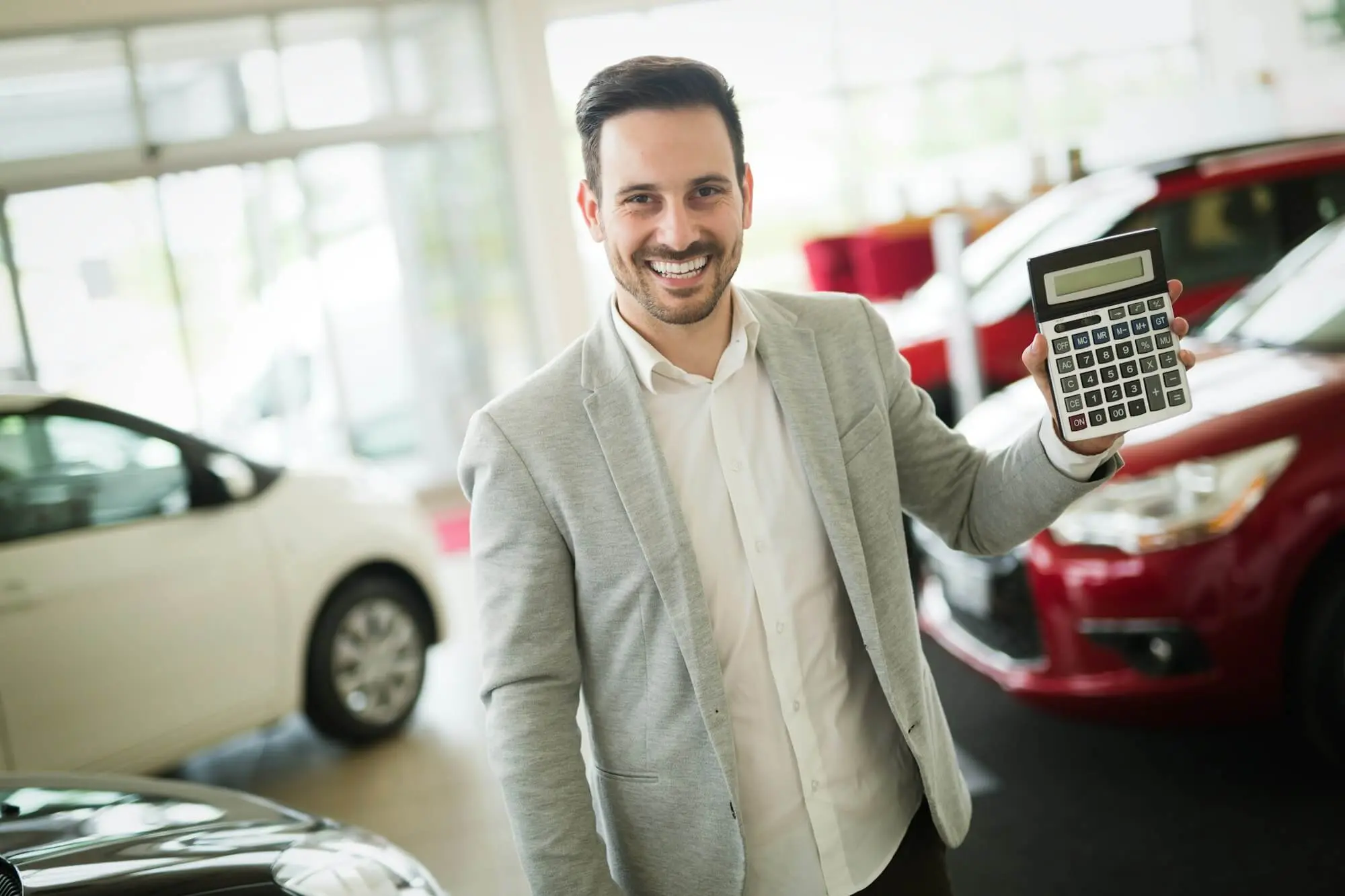 car-salesman-calculating-a-price-at-the-dealership-office.jpg